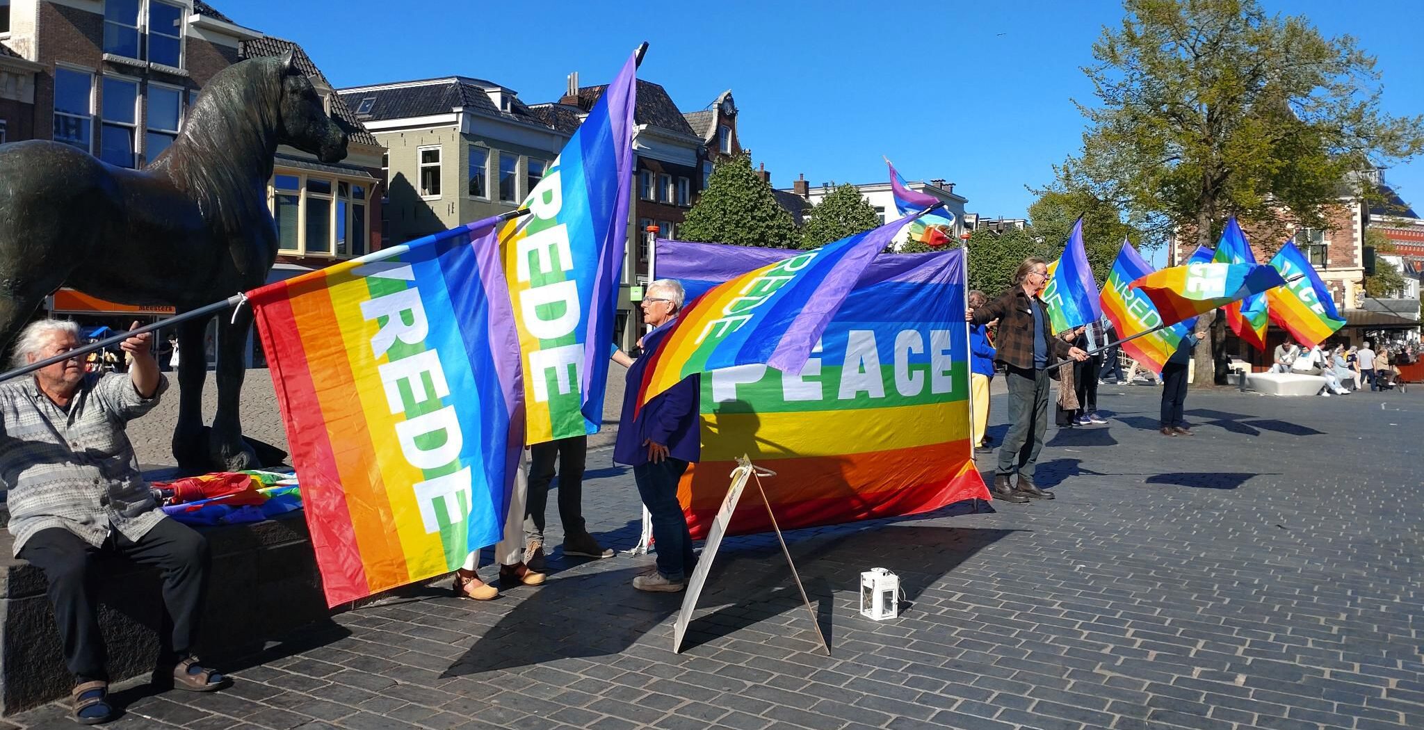 De kleurrijke vredesvlaggen trekken de aandacht op de Lange Pijp in Leeuwarden